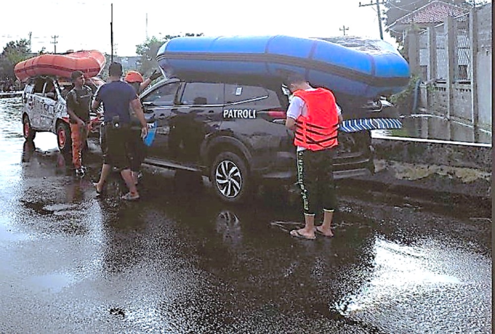 Kendaraan patroli membawa perahu karet di lokasi banjir